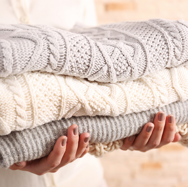 woman holding wool sweaters