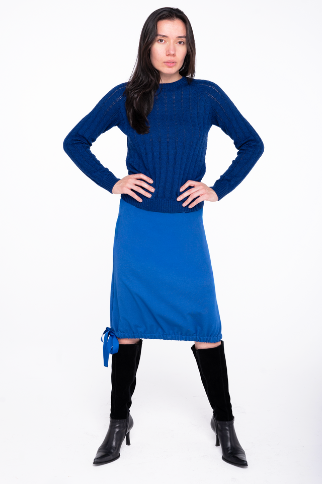 woman wearing a sapphire blue french terry skirt with a ribbon hem detail